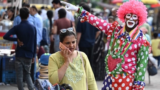 Gram it: Delhi's streets offer a glimpse of the city life. Here's how an artist dressed as a clown to gesture and attract customers, to a shop at a marketplace. (Photo: Sajjad HUSSAIN / AFP)