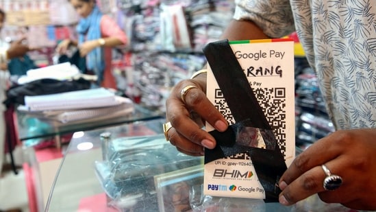 A shopkeeper ties a black band on a QR code scanner at his shop to protest against the implementation of Merchant Discount Rate (MDR) in UPI transactions