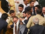 BJP MLAs being restrained during a protest in J&K assembly in Srinagar on Monday. (PTI)