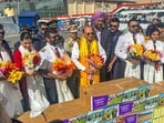 Lieutenant governor Vinai Kumar Saxena (centre) after presenting bouquets of the Ladakh-grown blooms to flight crew members carrying the cargo to Delhi, Mumbai, and Chandigarh from Leh airport on Tuesday. (HT Photo)