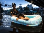 A man pulls a girl in an inflatable boat through floodwaters in Bang Kapi district, Bangkok. 