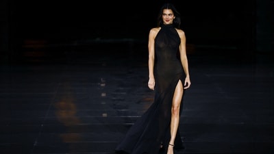 Model Kendall Jenner led the show in a sheer black gown that wrapped intricately down to the floor. With a high neck, a thigh-high slit, and visible ivory lingerie, she completed the look with sleek black stiletto sandals. (Reuters)