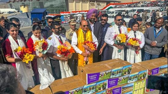 Lieutenant governor Vinai Kumar Saxena (centre) after presenting bouquets of the Ladakh-grown blooms to flight crew members carrying the cargo to Delhi, Mumbai, and Chandigarh from Leh airport on Tuesday. (HT Photo)