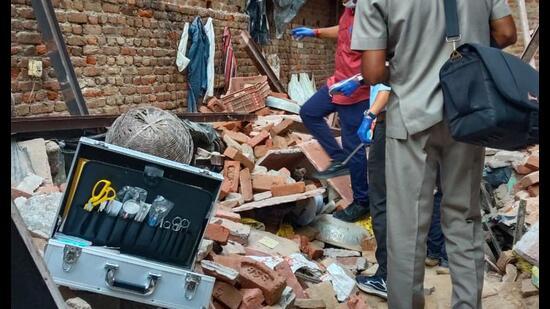 Officials inspect the site after an under-construction floor of a building collapsed in Tahirpur on Tuesday. (HT)