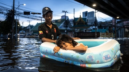 A man pulls a girl in an inflatable boat through floodwaters in Bang Kapi district, Bangkok.