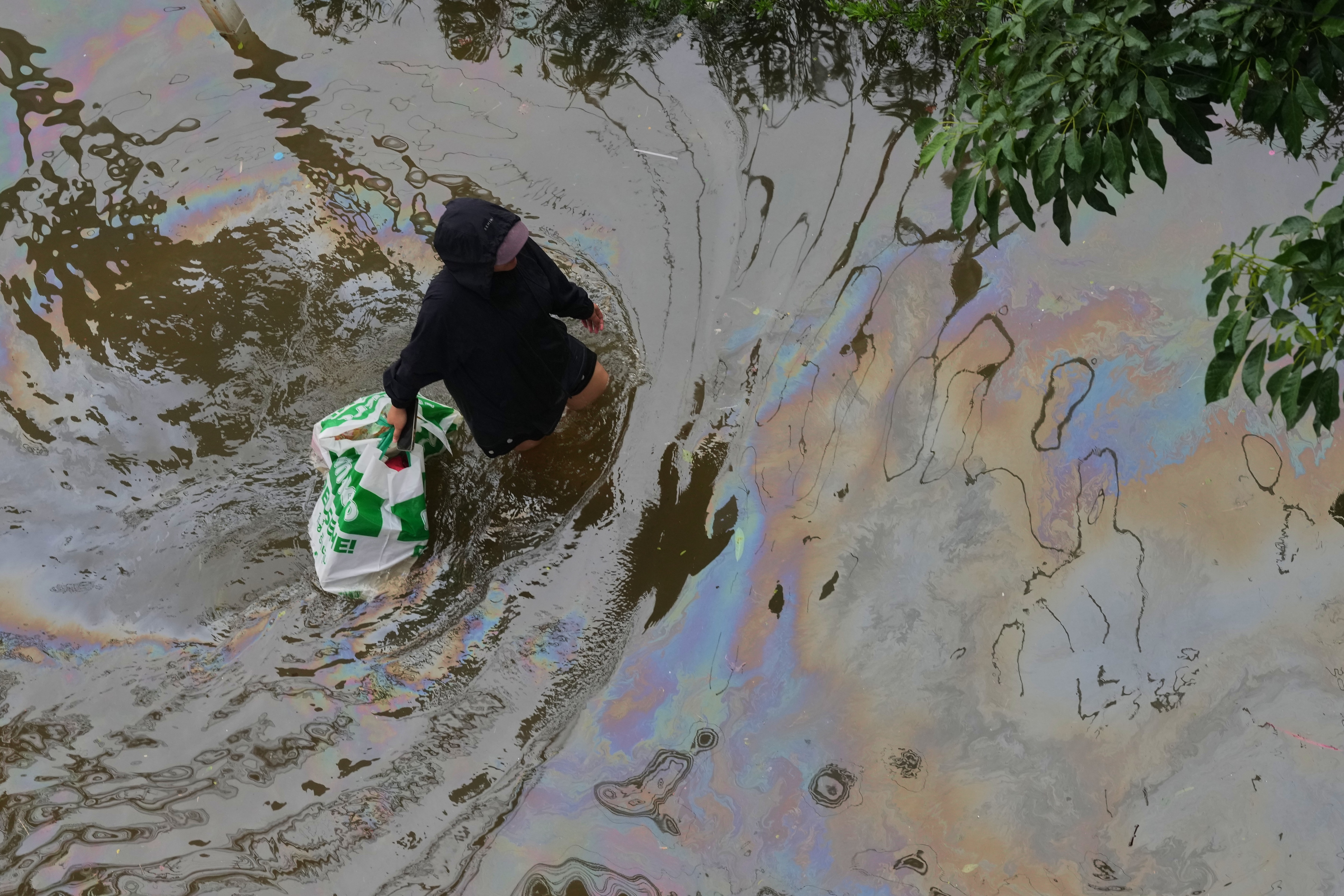 A woman wades through floodwaters after heavy rain in Bangkok, Thailand, on Sunday. (File Photo/AP) A woman wades through floodwaters after heavy rain in Bangkok, Thailand, on Sunday. (File Photo/AP)