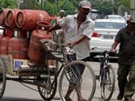 A-delivery-man-carrying-LPG-cylinders-at-Kitchlu-Nagar-in-Ludhiana-on-Wednesday-JS-Grewal-HT