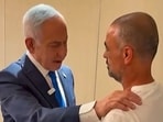 This screen grab taken from video footage released by the Israeli Prime Minister's Office shows Israel's Prime Minister Benjamin Netanyahu (L) meeting a man named Yaniv, describing him as one of the passengers who managed to break into the flydubai aircraft's cockpit.