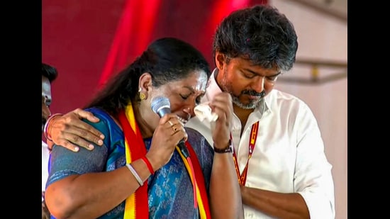 Tamil Nadu CM C Joseph Vijay comforts TVK’s Dharapuram bypoll candidate P Sathyabama at the rally in Tiruppur district on Wednesday. (PTI)