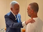 Israel's Prime Minister Benjamin Netanyahu (L) meeting a man named Yaniv, describing him as one of the passengers who managed to break into the flydubai aircraft's cockpit, at Israel's Ben Gurion Airport in Lod on September 30.