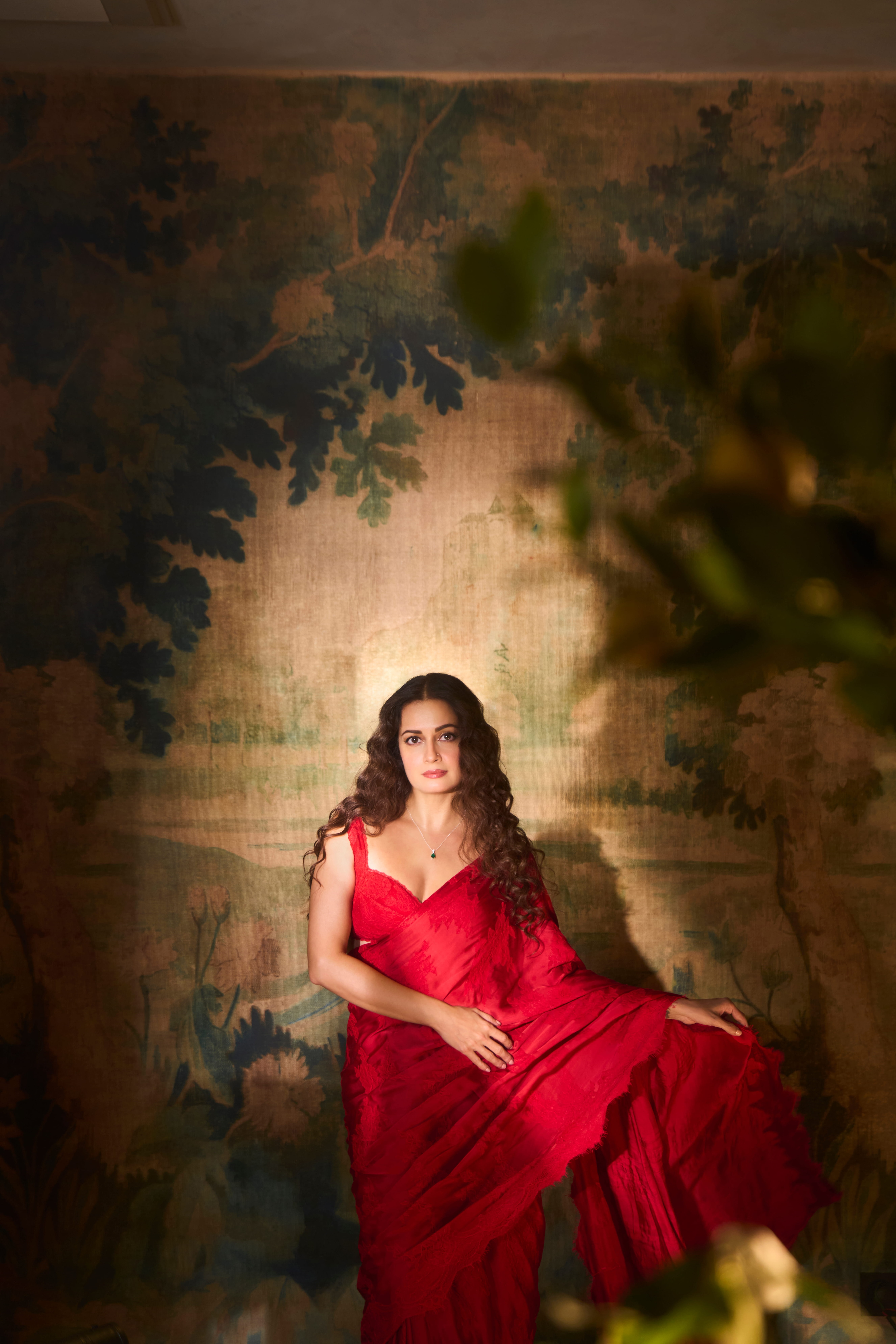 The actor wears a vibrant red saree from Roseroom by Isha Jajodia styled with a delicate pendant necklace from CLARA.