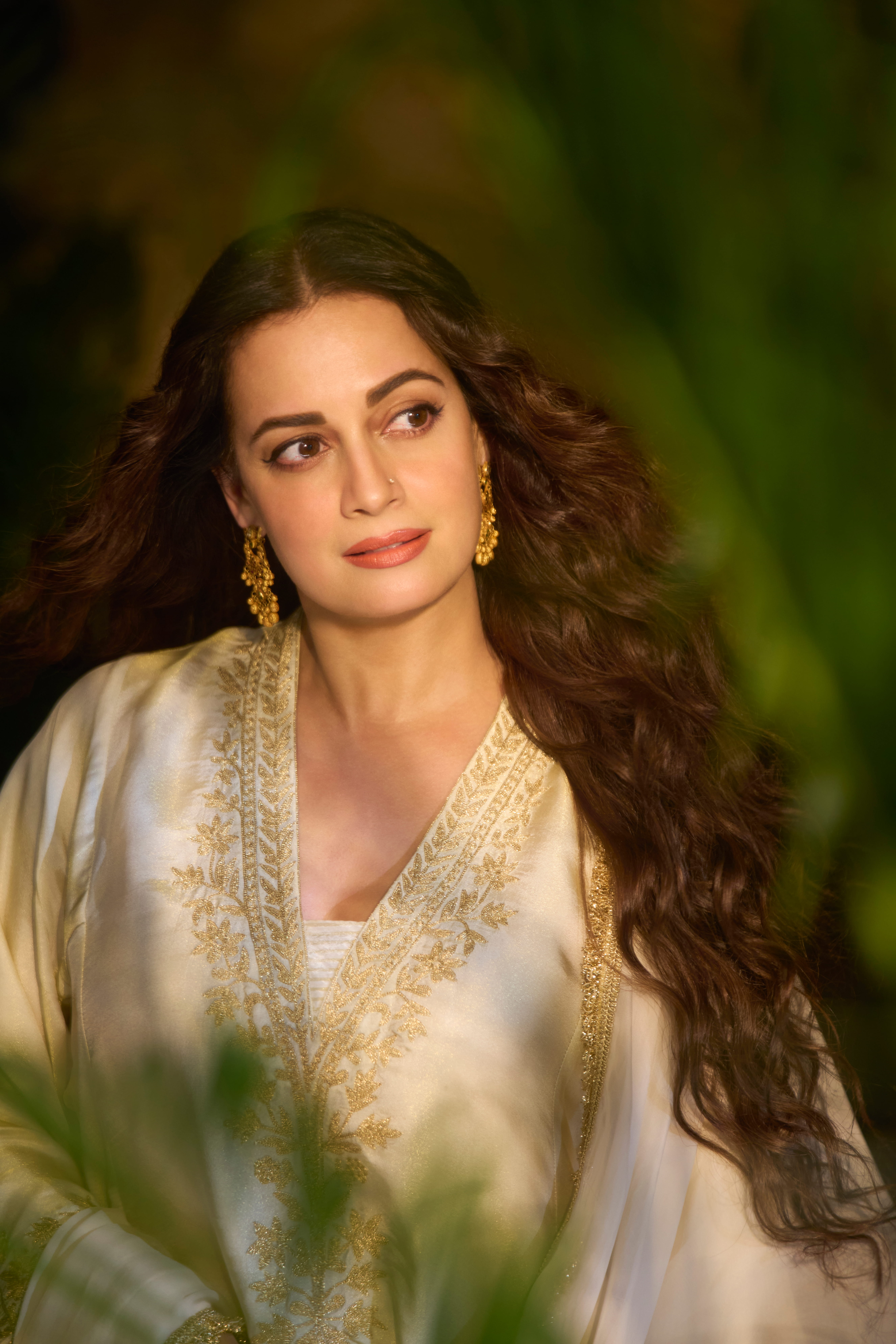 Dia wears an ivory satin tissue pheran and matching pants set by House of DSAK, detailed with intricate Kashmiri Aari Tilla embroidery and finished with bold statement earrings from Manubhai Jewellers.
