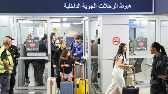 Passengers from an earlier diverted flydubai flight are seen after landing at Israel's Ben Gurion Airport in Lod. (AFP)