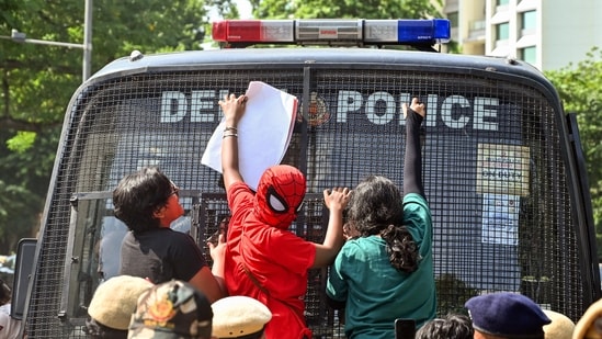 A protester in a Spideman costume climbs onto the front glass of a police bus during a protest seeking Chief Election Commissioner Gyanesh Kumar's resignation over voter roll deletions near Jantar Mantar, in New Delhi on Friday. 