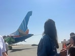 Passengers stand beside Flydubai Flight FZ1073, with damage visible to the aircraft's tail, after it made an emergency landing at Prince Sultan bin Abdulaziz International Airport in Tabuk, Saudi Arabia, Wednesday, 