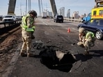Police officers work at a site of the North Bridge hit by a Russian drone strike, amid Russia's attack on Ukraine, in Kyiv, Ukraine October 4, 2026.