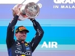 Red Bull driver Max Verstappen of the Netherlands celebrates with his trophy on the podium after winning the Bahrain Grand Prix.