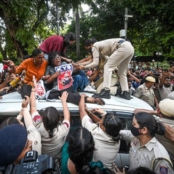 Several supporters climb atop a police vehicle carrying AISA leader Neha Bora after she was detained during a protest march by members of AISA and other student organisations demanding the resignation of CEC Gyanesh Kumar.