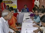 Booth Level Officers (BLOs) verify voter details during the special intensive revision (SIR) of electoral rolls at a special campaign weekend organised by Shivamogga Municipal Corporation, in Shivamogga. (PTI FILE)