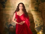 The actor wears a vibrant red saree from Roseroom by Isha Jajodia styled with a delicate pendant necklace from CLARA.