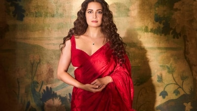 The actor wears a vibrant red saree from Roseroom by Isha Jajodia styled with a delicate pendant necklace from CLARA.