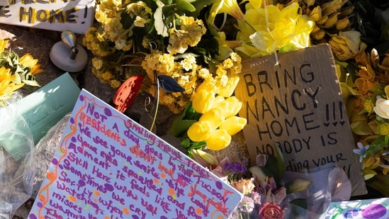 FILE - A collection of yellow flowers and notes sit at the home of Nancy Guthrie, the missing mother of "Today" show host Savannah Guthrie, in Tucson, Ariz., March 6, 2026. (AP Photo/Rebecca Noble, File)
