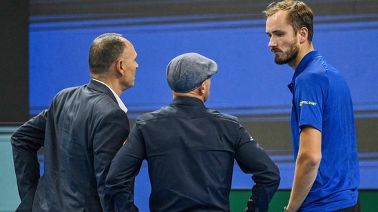 Russia's Daniil Medvedev (R) speaks with the match umpire (L) and an ATP official after he was disqualified for hitting a ball into the stands, injuring a spectator,