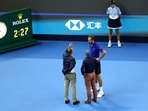 Russia's Daniil Medvedev speaks with officials after he hit a ball into the crowd during his semi-final match against Serbia's Novak Djokovic