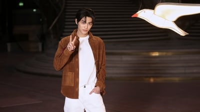 Keonho poses upon arrival at the Chanel Women's Wear Spring Summer 2027 collection presented in Paris, France. He wore a white tee with matching white pants and a suede brown shacket.&nbsp; (AP Photo/Thomas Padilla)