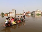 Locals travel along a flooded road in the Daudnagar area of Faizullaganj following a rise in the Gomti River's water level in Lucknow,on Monday (Deepak Gupta/HT)