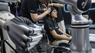 A BrainCo technician has electrodes attached to his head for a demonstration at the exhibition of the World Robot Conference in Beijing, China, on Wednesday, Aug. 19, 2026. (Bloomberg) A BrainCo technician has electrodes attached to his head for a demonstration at the exhibition of the World Robot Conference in Beijing, China, on Wednesday, Aug. 19, 2026. (Bloomberg)