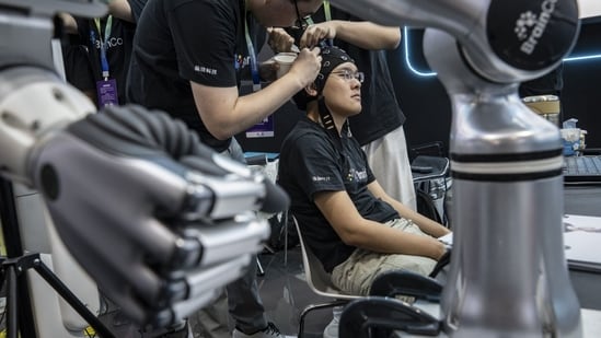 A BrainCo technician has electrodes attached to his head for a demonstration at the exhibition of the World Robot Conference in Beijing, China, on Wednesday, Aug. 19, 2026. (Bloomberg)