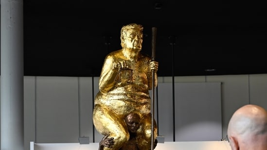 Visitors looks at a scupture titled "The Orange Plague" by Danish artist Jens Galschiot, depicting U.S. President Donald Trump.