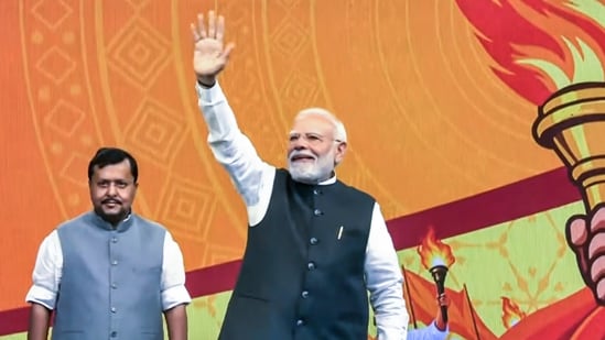 Prime Minister Narendra Modi waves to supporters upon his arrival to address the Viksit Bharat Sankalp Sabha, in New Delhi.