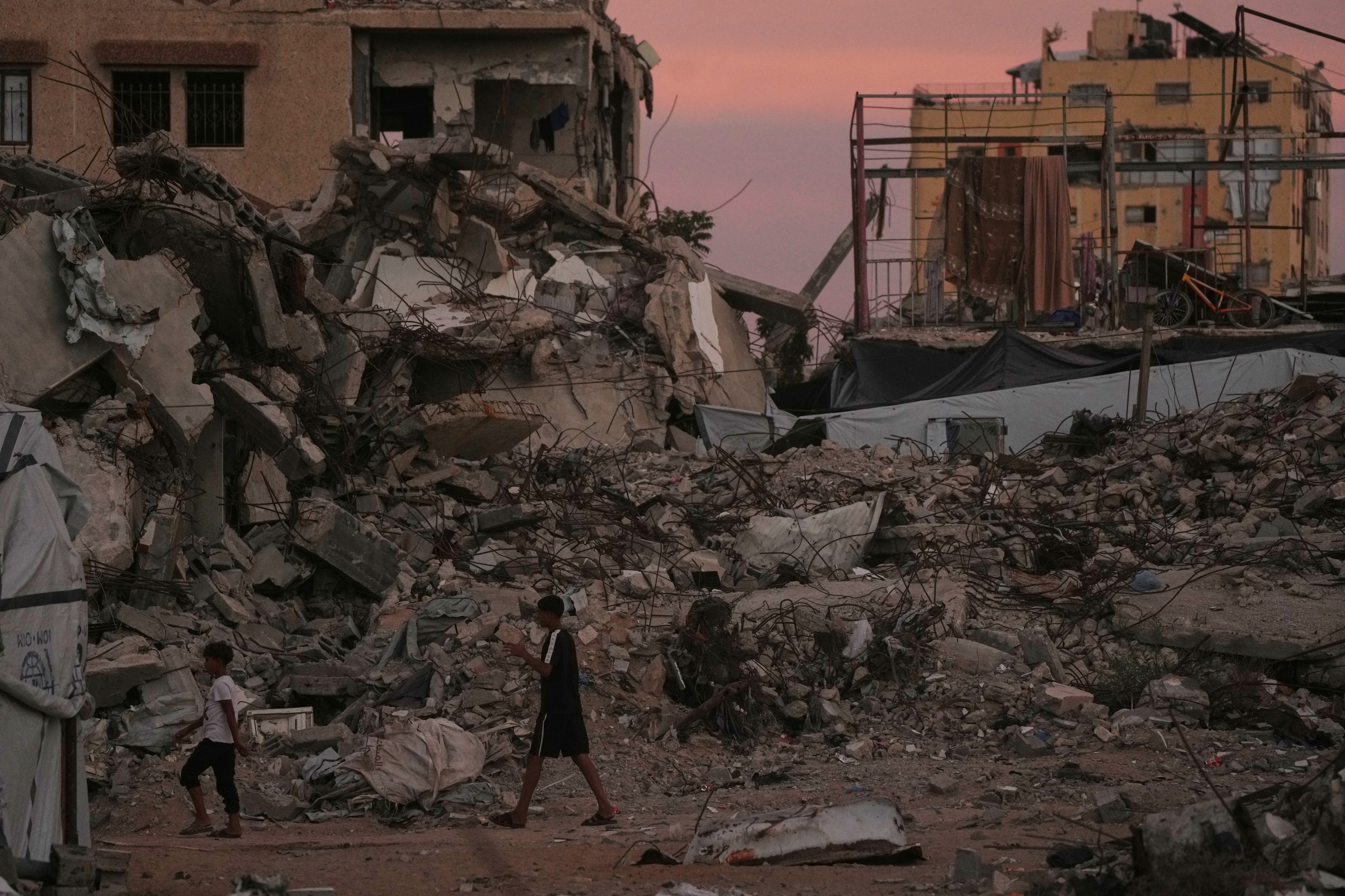 Palestinians walk along a street surrounded by buildings destroyed in Israeli military strikes during the Israel-Hamas war in Gaza City, Tuesday, Oct. 6, 2026. (AP Photo/Jehad Alshrafi) Palestinians walk along a street surrounded by buildings destroyed in Israeli military strikes during the Israel-Hamas war in Gaza City, Tuesday, Oct. 6, 2026. (AP Photo/Jehad Alshrafi)
