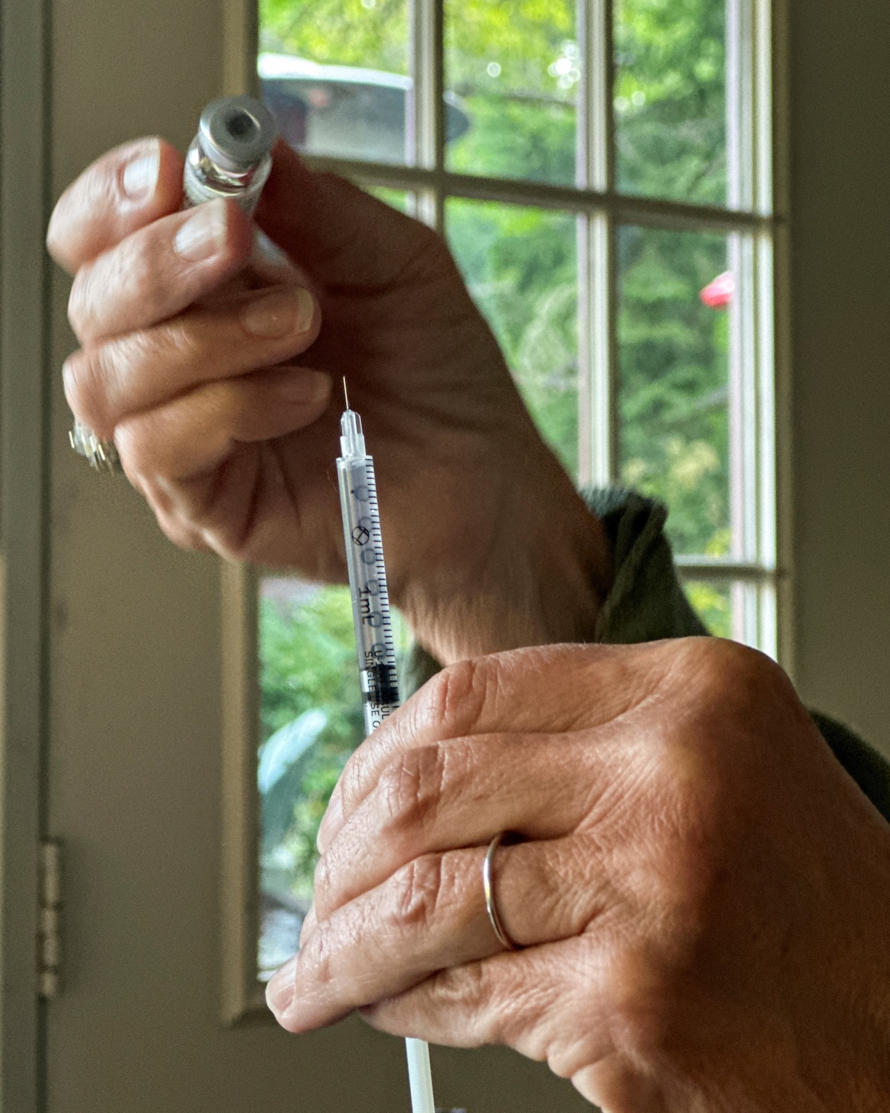 A woman prepares an injection of a GLP-1 weight-loss drug. A woman prepares an injection of a GLP-1 weight-loss drug.