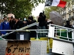 A protester holds a French flag behind a barricade to block the Boulevard Saint-Germain during a blockade of Sciences Po university in Paris as part of nationwide student protests demanding better school conditions.