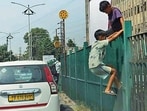 In the absence of foot overbridge, children climbing a railing in Ludhiana . (Gurpreet Singh/HT)