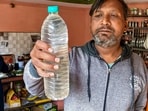 A person shows a sample of the drinking water that is being collected following a diarrhoea outbreak caused by contaminated water, at Bhagirathpura area, in Indore