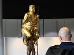 Visitors looks at a sculpture titled "The Orange Plague" by Danish artist Jens Galschiot, depicting US President Donald Trump. 