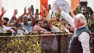 Prime Minister Narendra Modi waves to supporters during the Viksit Bharat Sankalp Sabha at the Indira Gandhi Indoor Stadium, in New Delhi. (PTI)