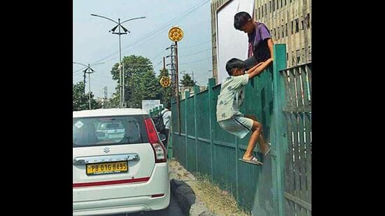 In the absence of foot overbridge, children climbing a railing in Ludhiana . (Gurpreet Singh/HT)