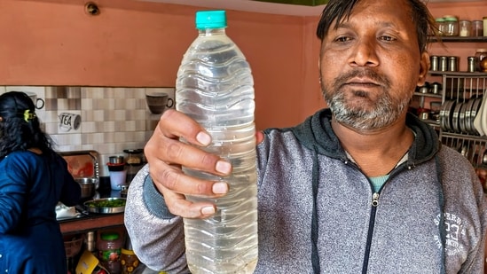 A person shows a sample of the drinking water that is being collected following a diarrhoea outbreak caused by contaminated water, at Bhagirathpura area, in Indore