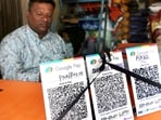 Bhopal, Oct 08 (ANI): A shopkeeper covers QR code with black ribbons in the wake of the implementation of Merchant Discount Rate (MDR) for UPI transactions, as wholesale pulses and rice merchants observe NO UPI Day, in Bhopal on Thursday. (ANI Photo)(Sanjeev Gupta)
