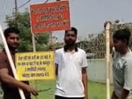 Residents standing on a makeshift raft with placards. (Sourced)