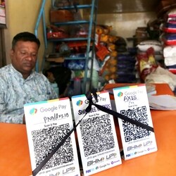 Bhopal, Oct 08 (ANI): A shopkeeper covers QR code with black ribbons in the wake of the implementation of Merchant Discount Rate (MDR) for UPI transactions, as wholesale pulses and rice merchants observe NO UPI Day, in Bhopal on Thursday. (ANI Photo)