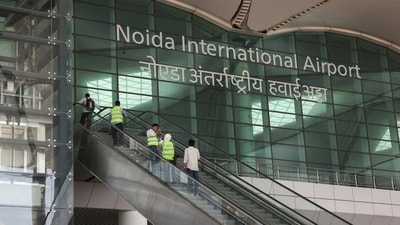 People stand on an escalator as they enter Noida International Airport (NIA) during a media visit to the project site, in Noida. (REUTERS)