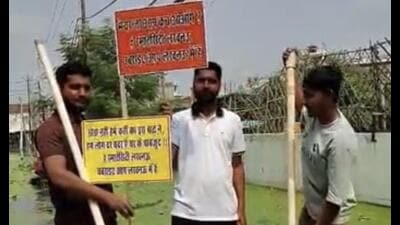 Residents standing on a makeshift raft with placards. (Sourced)