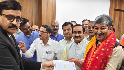 Secretary state assembly Hem Pant handing over certificafe of election to BJP leader Dinesh Arya. Secretary state assembly Hem Pant handing over certificafe of election to BJP leader Dinesh Arya.