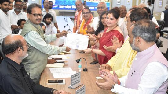 BJP candidate Priyanka Singh Rawat collects her certificate from the returning officer after she was elected unopposed to the Rajya Sabha on Friday. (SOURCED IMAGE)